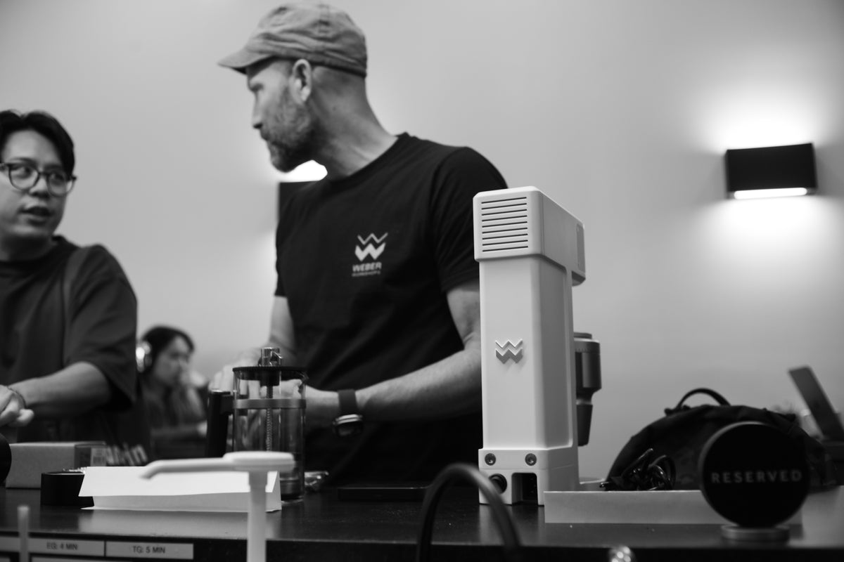 Douglas Weber speaking beside The Bird coffee brewer at Kaizen & Coffee