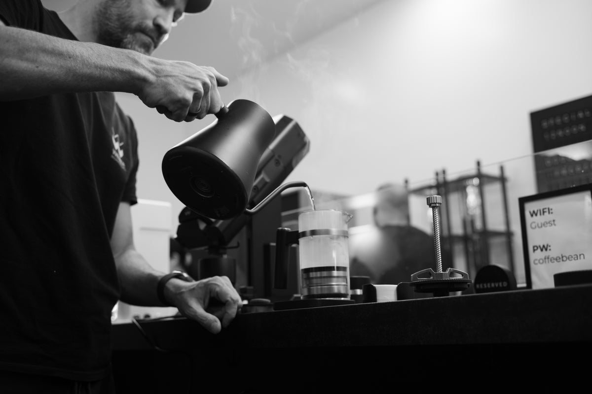 Water being poured into a glass coffee brewer