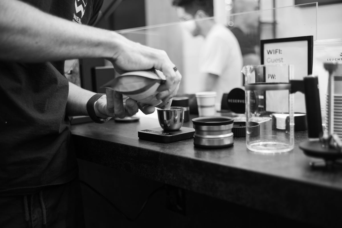 Douglas Weber pouring brewed coffee into tasting cups