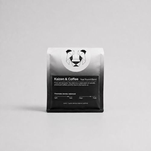Kaizen & Coffee Year Round Blend whole bean coffee in a black and silver bag on a light gray background.