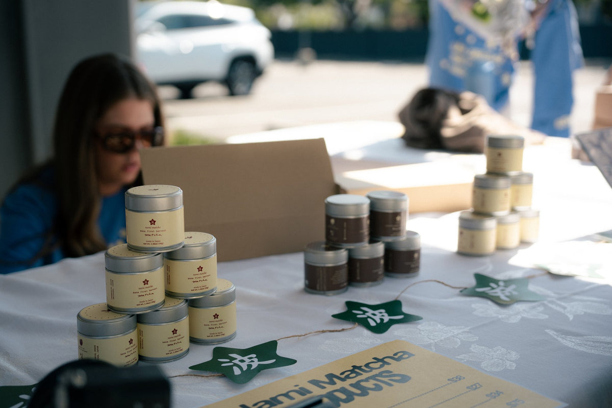 Nami Matcha tins arranged on the event merchandise table