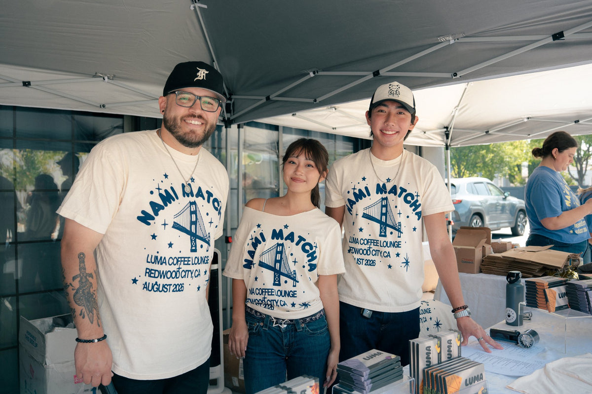 Three Nami Matcha event team members at the outdoor merchandise table