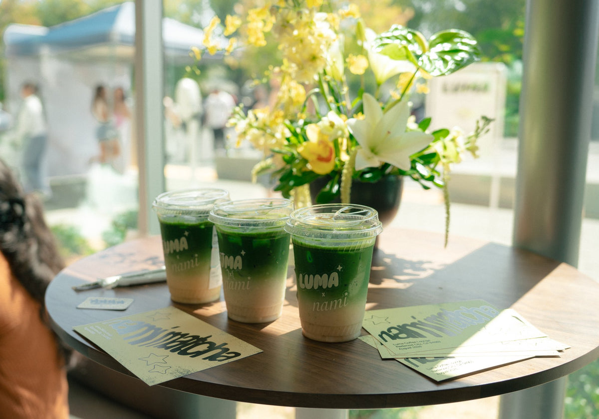 Luma Coffee matcha drinks displayed beside flowers and event menus