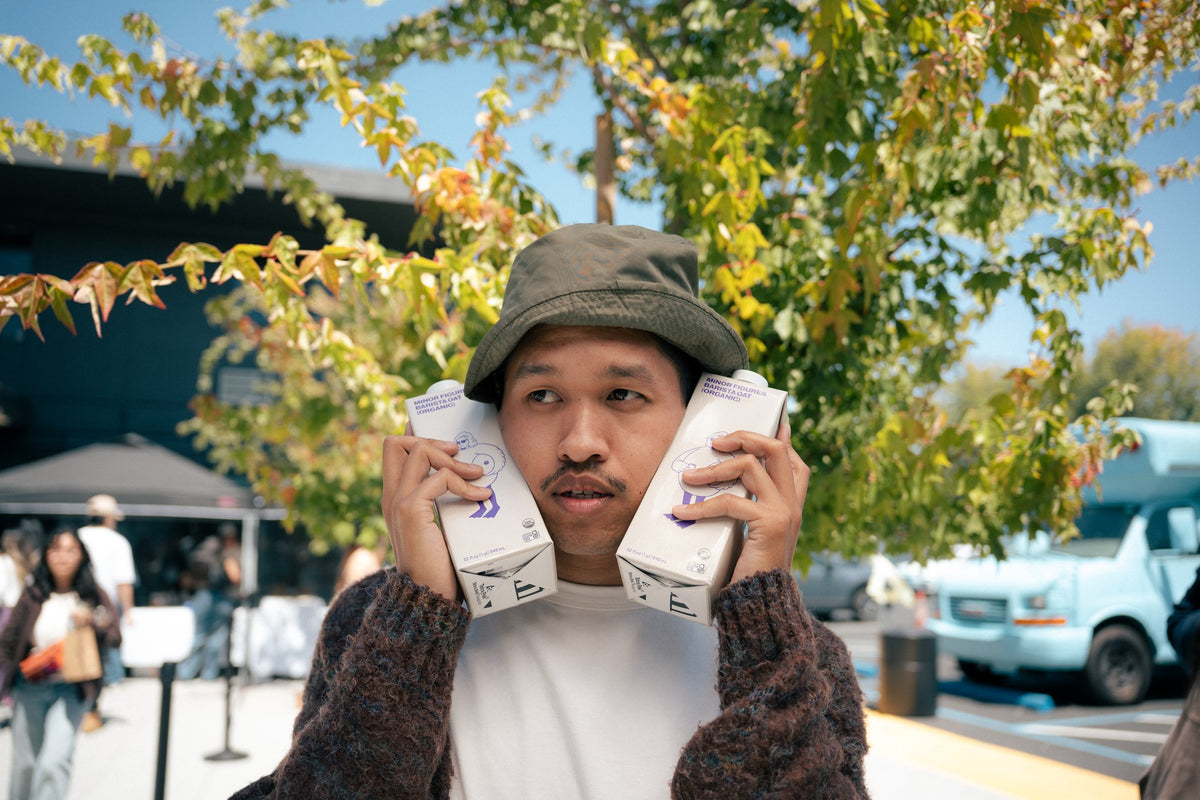 Event attendee playfully holding two Nami Matcha cartons